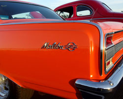 The iconic Malibu SS logo pops against the exquisite orange paint job on this 1964 Chevrolet Chevelle