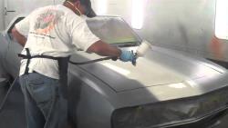 View of Rodney with spray gun in hand painting his Camaro
