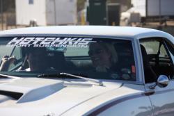 Front driver side view of Suzy Bauter behind the wheel with Rodney riding shotgun in the Camaro