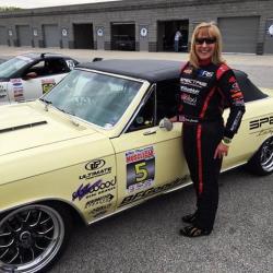 View of Lynda Jacobs in her Spectre Performance Driving Suit with her '66 Chevelle Wimpy