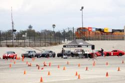 Drivers staging at start line on course, with officials nearby for timing.