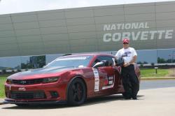 Photo of Jason Luebcke next to "Bama" in front of the National Corvette Museum sign & 