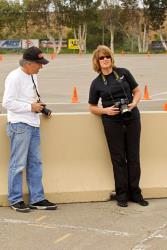 Mary Pozzi with camera in hand having conversation with fellow photographer